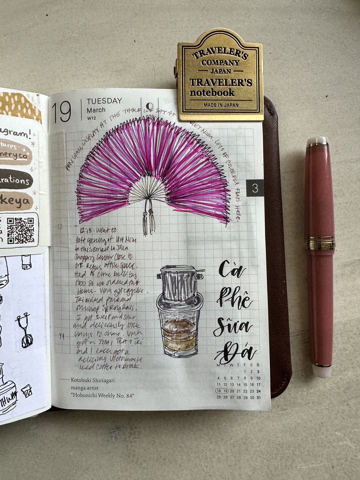 A Hobonichi journal page with a pink paper fan drawing, a sketched Vietnamese iced coffee, and Ca Phe Sua Da lettering