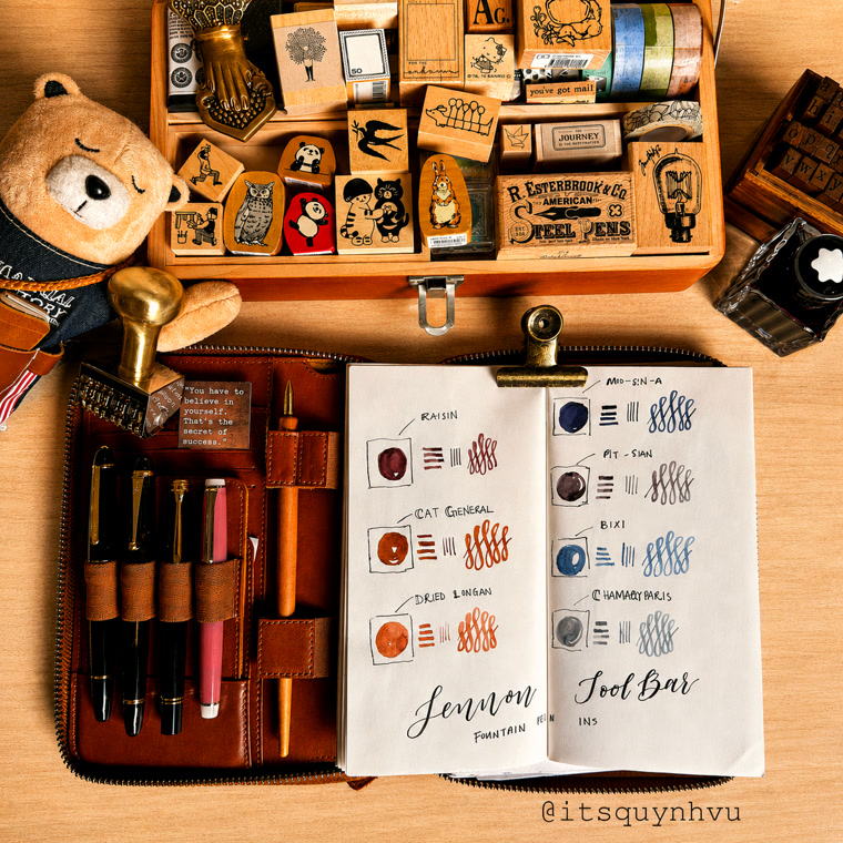 A flatlay of Quynh's pens, stamps, and an open journal of ink swatches